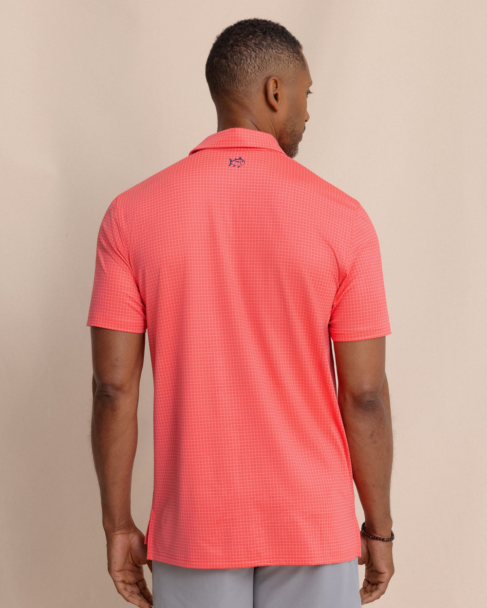 The back view of the Southern Tide Driver Spring Geo Printed Polo by Southern Tide - Sunkist Coral