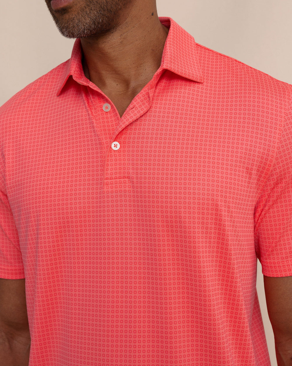 The detail view of the Southern Tide Driver Spring Geo Printed Polo by Southern Tide - Sunkist Coral