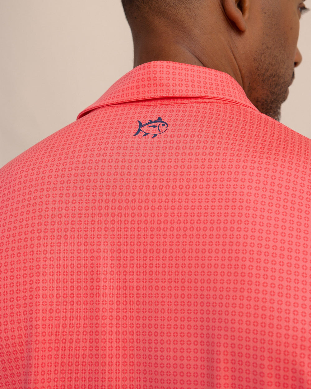 The detail view of the Southern Tide Driver Spring Geo Printed Polo by Southern Tide - Sunkist Coral