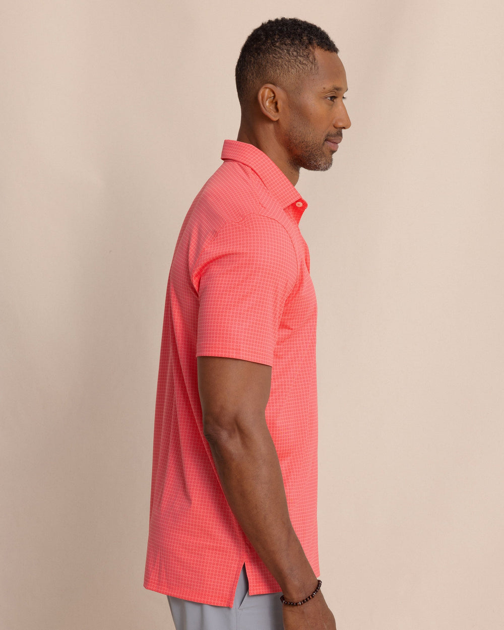 The side view of the Southern Tide Driver Spring Geo Printed Polo by Southern Tide - Sunkist Coral