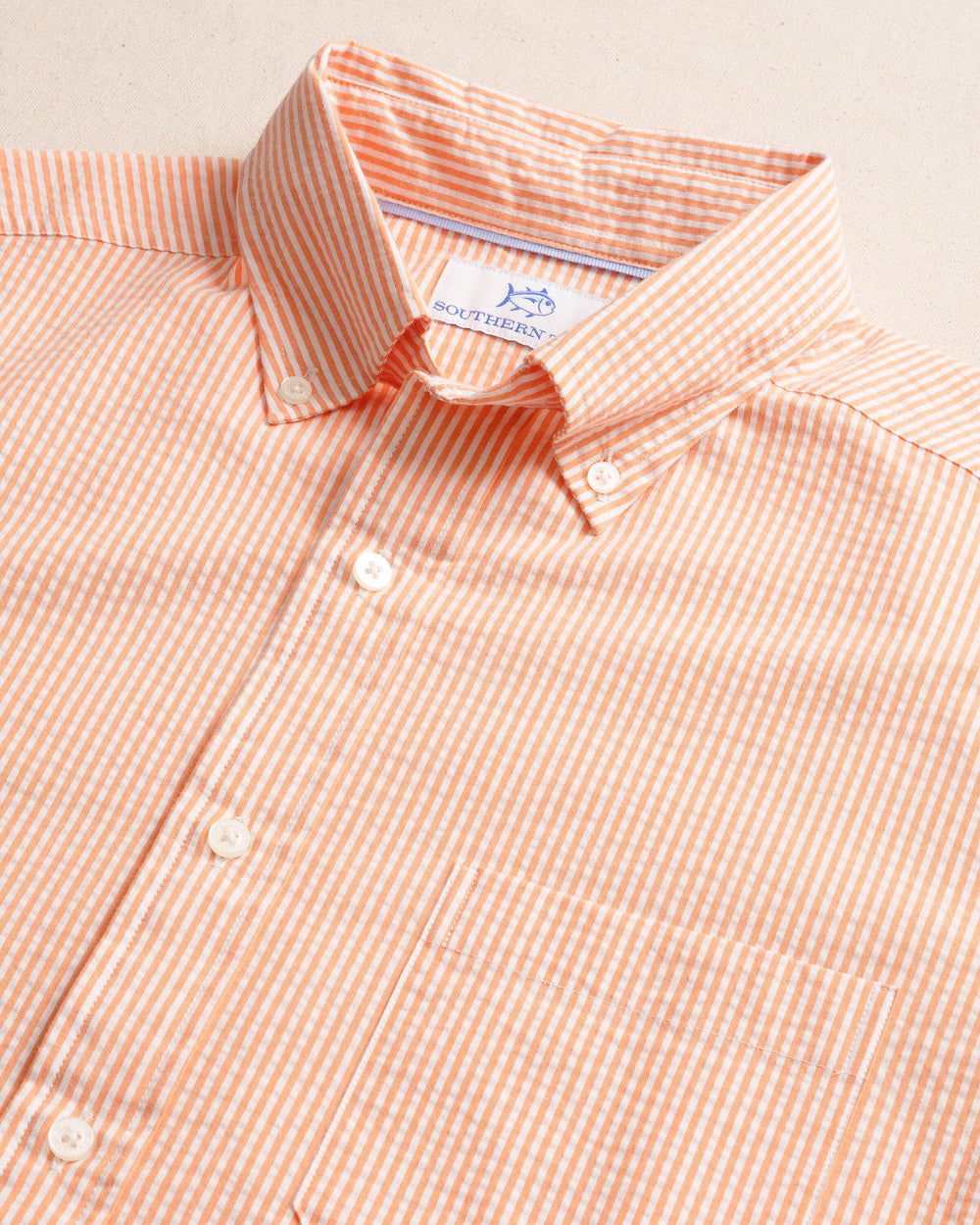 The detail view of the Southern Tide Folly Field Stripe Seersucker Short Sleeve Sport Shirt by Southern Tide - Celosia Orange