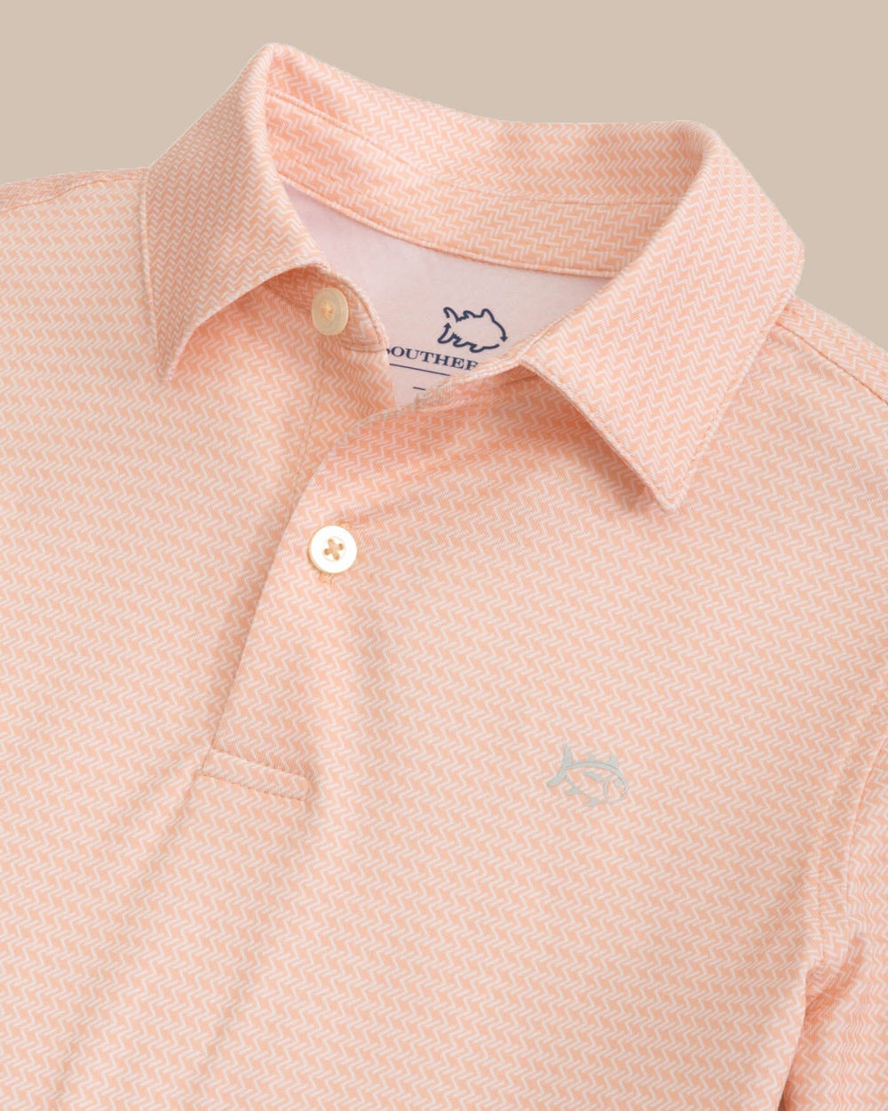 The detail view of the Southern Tide Kids Driver Getting Ziggy With It Printed Polo by Southern Tide - Apricot Blush Coral