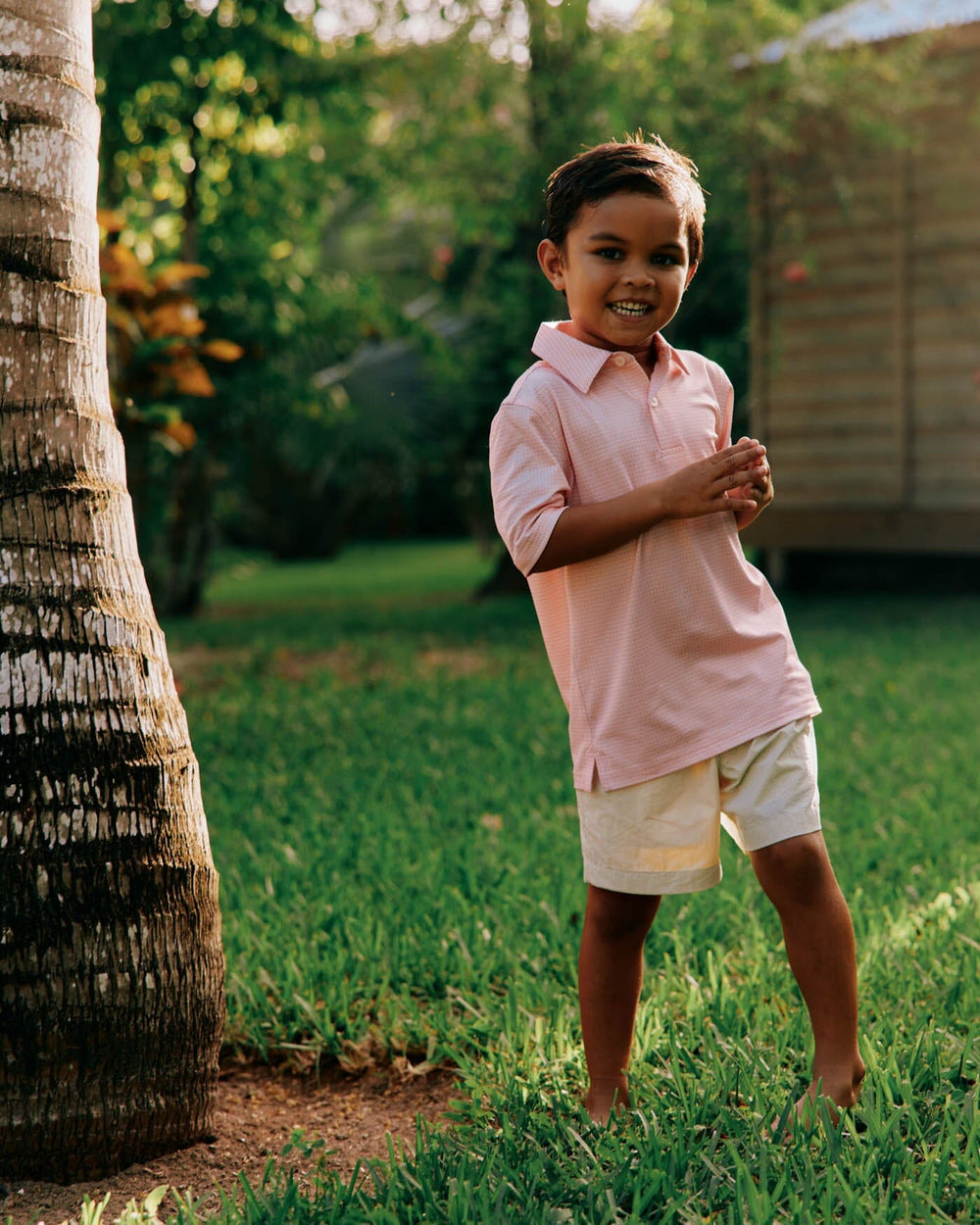 The front view of the Southern Tide Kids Driver Getting Ziggy With It Printed Polo by Southern Tide - Apricot Blush Coral