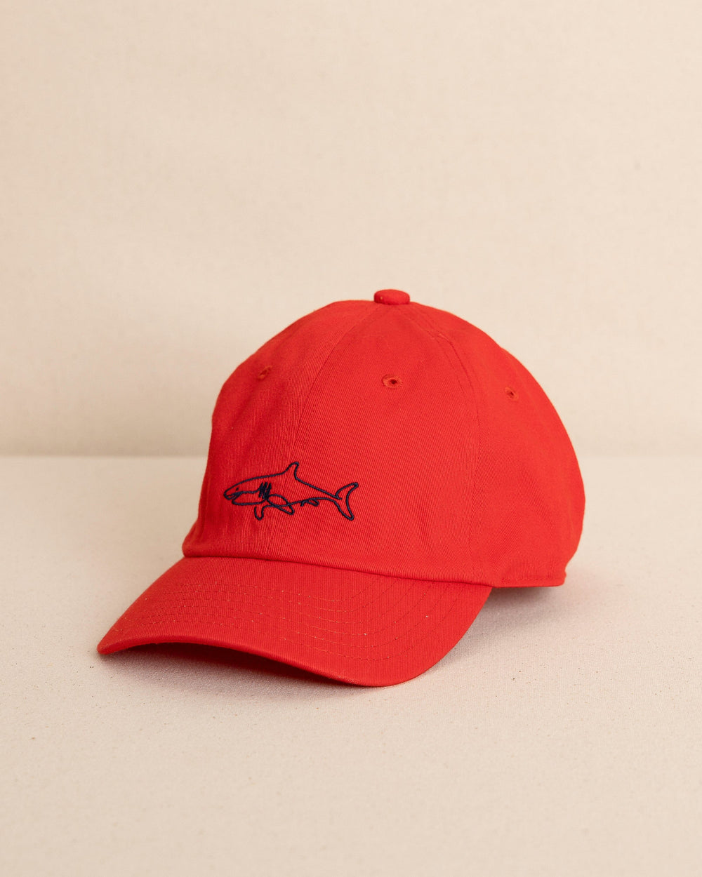 The front view of the Southern Tide Kids Uh Oh Sharks Leather Strap Hat by Southern Tide - Poppy Red