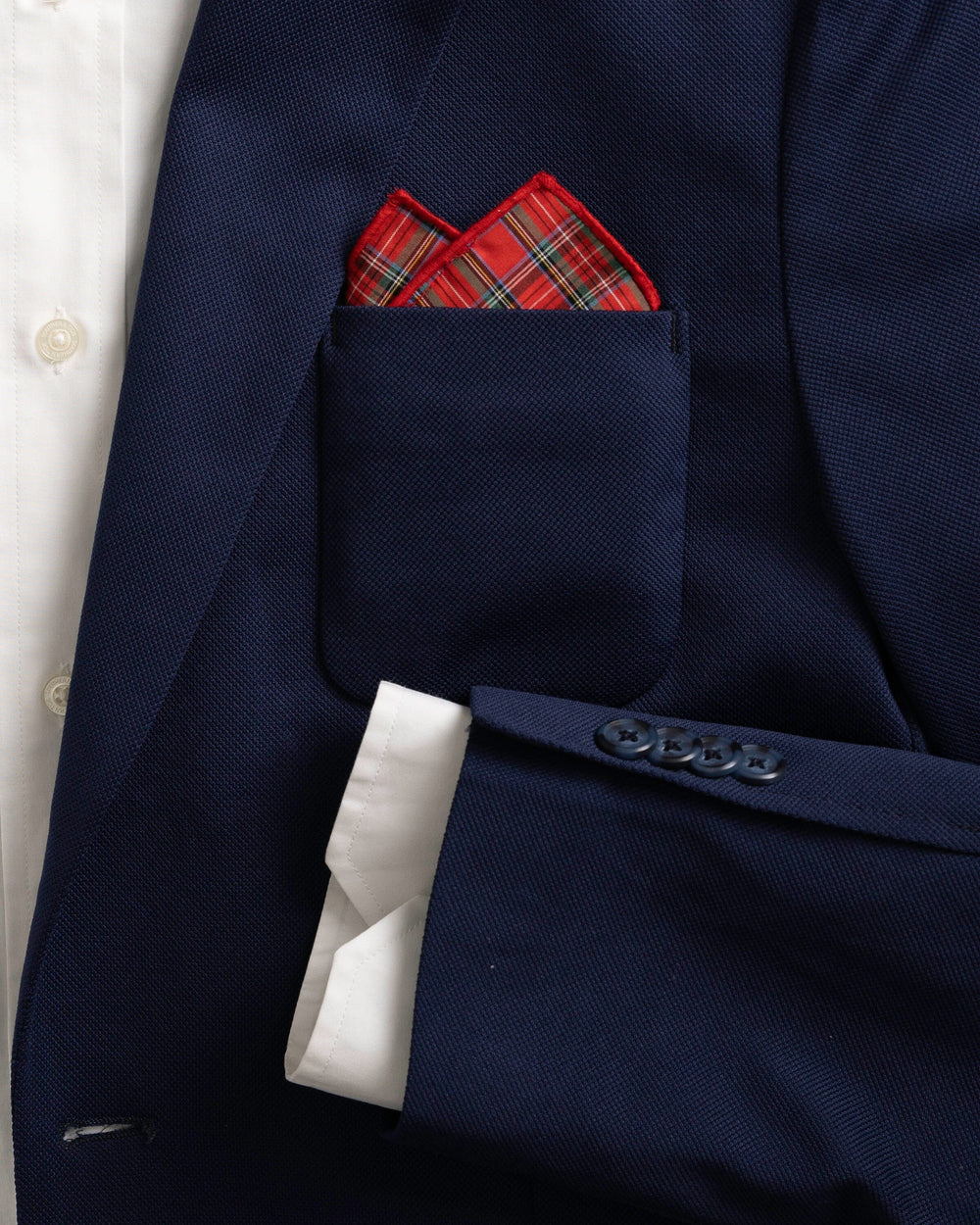 The detail coat view of the High Cotton MacIntosh Tartan Pocket Square at Southern Tide - Red