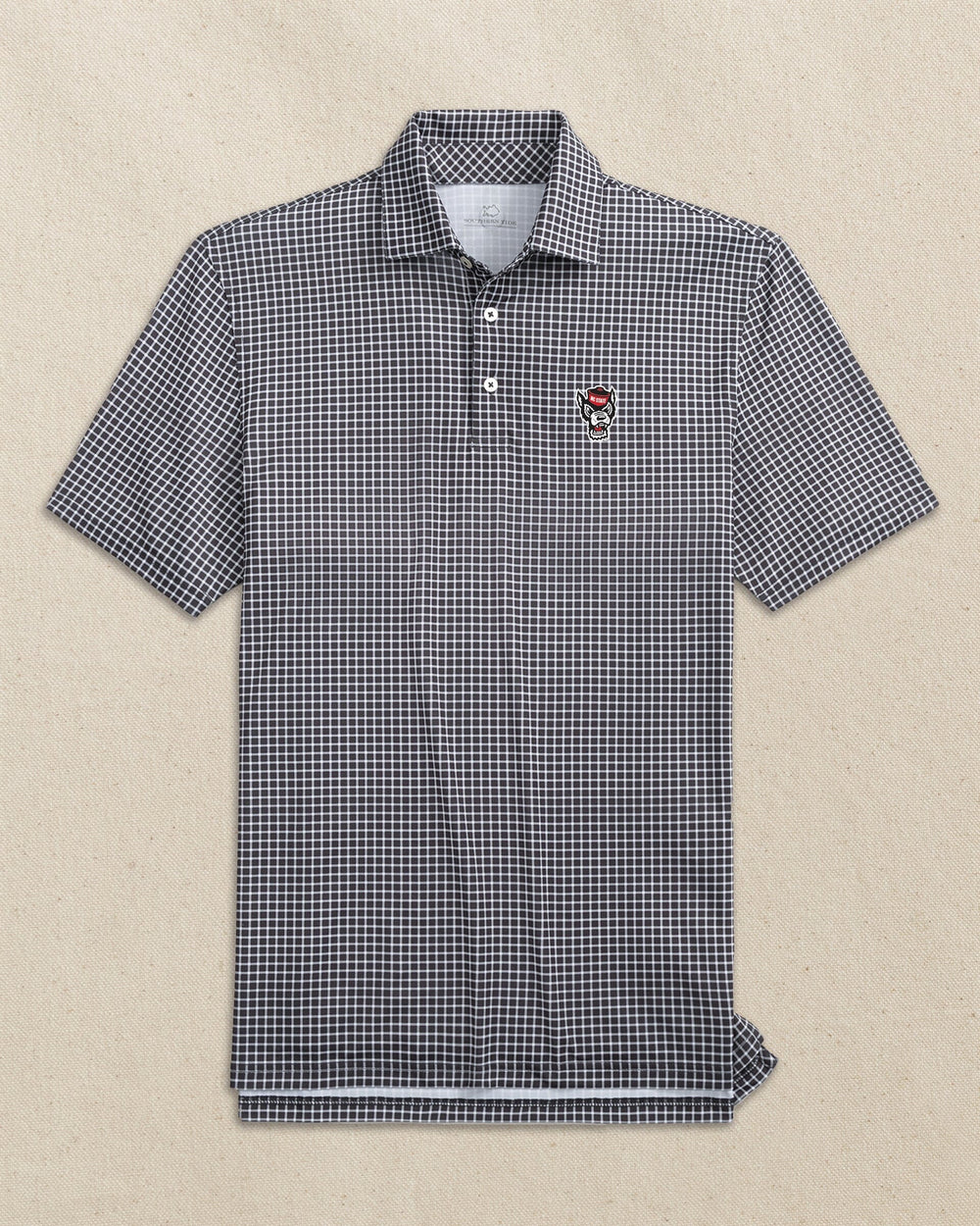 The front view of the Southern Tide NC State Wolf Head Driver Dunes Edge Plaid Polo by Southern Tide - Black