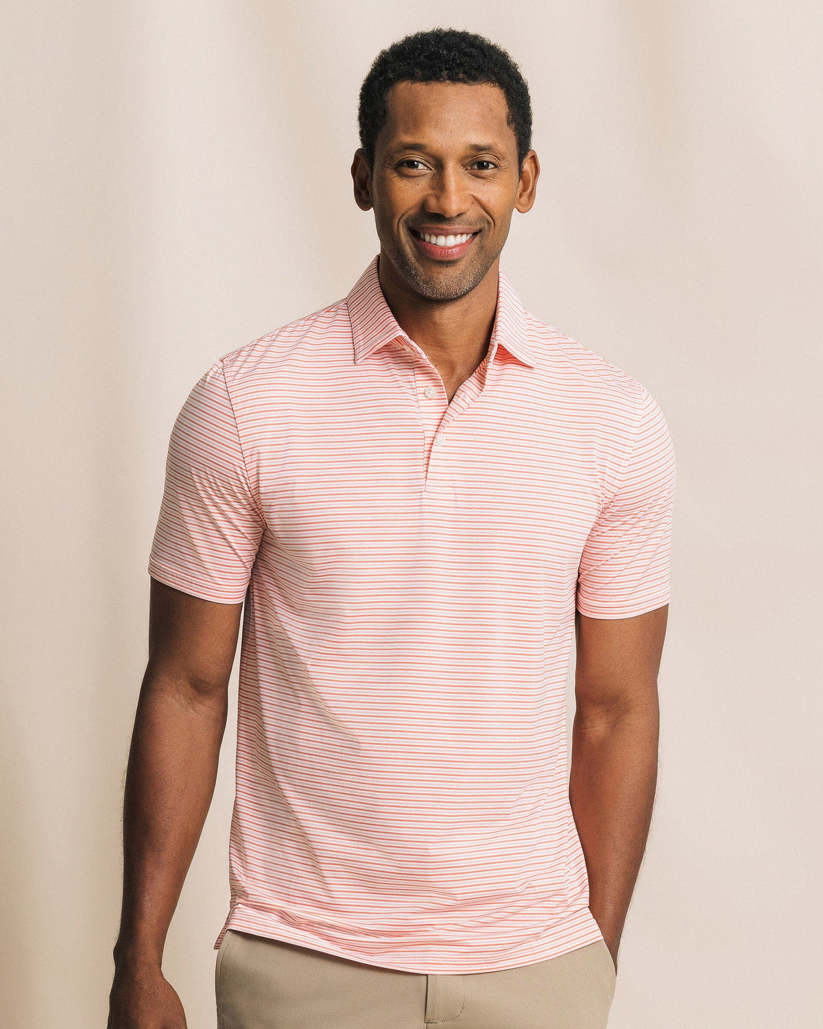 The front view of the Southern Tide Pelican Landing Stripe Coastal Breeze® Performance Polo by Southern Tide - Orange Blossom
