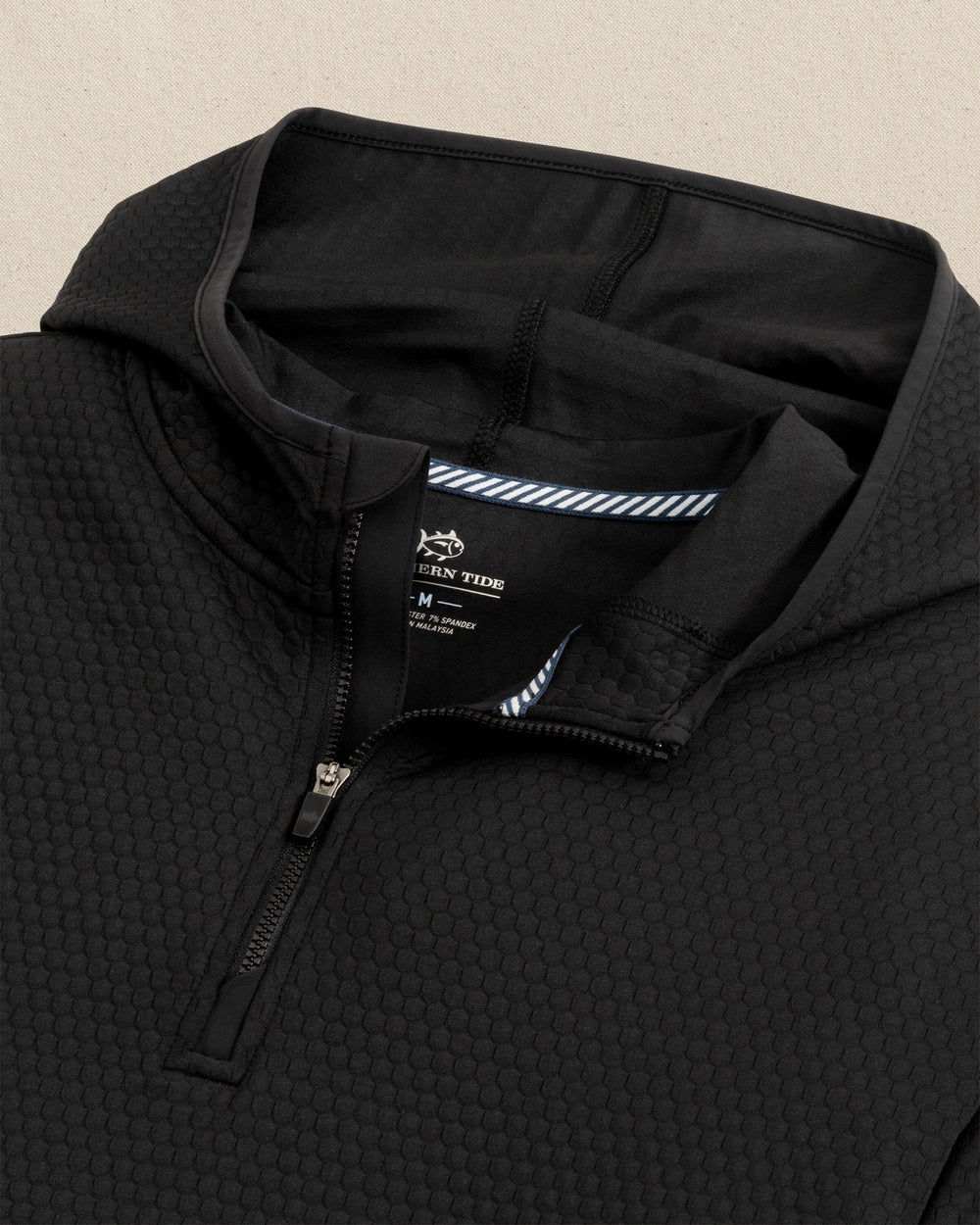 The detail view of the Southern Tide Scuttle Performance Quarter Zip Hoodie by Southern Tide - Caviar Black