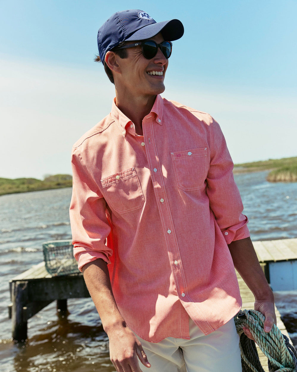 The lifestyle view of the Southern Tide Dock Shirt by Southern Tide - Sunkist Coral