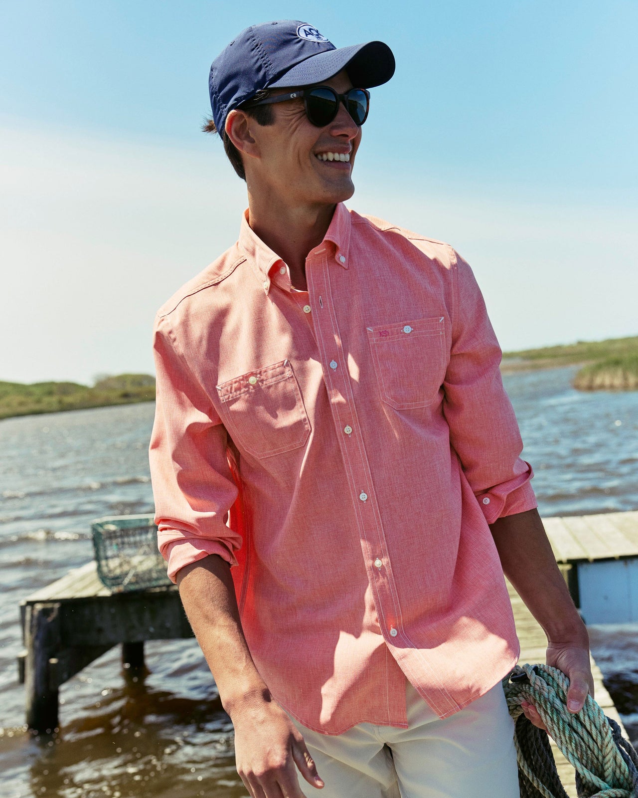 The lifestyle view of the Southern Tide Dock Shirt by Southern Tide - Sunkist Coral