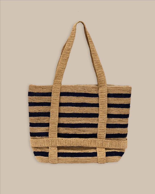 The front view of the Southern Tide Striped Straw Hat Carrier Beach Tote by Southern Tide - Navy