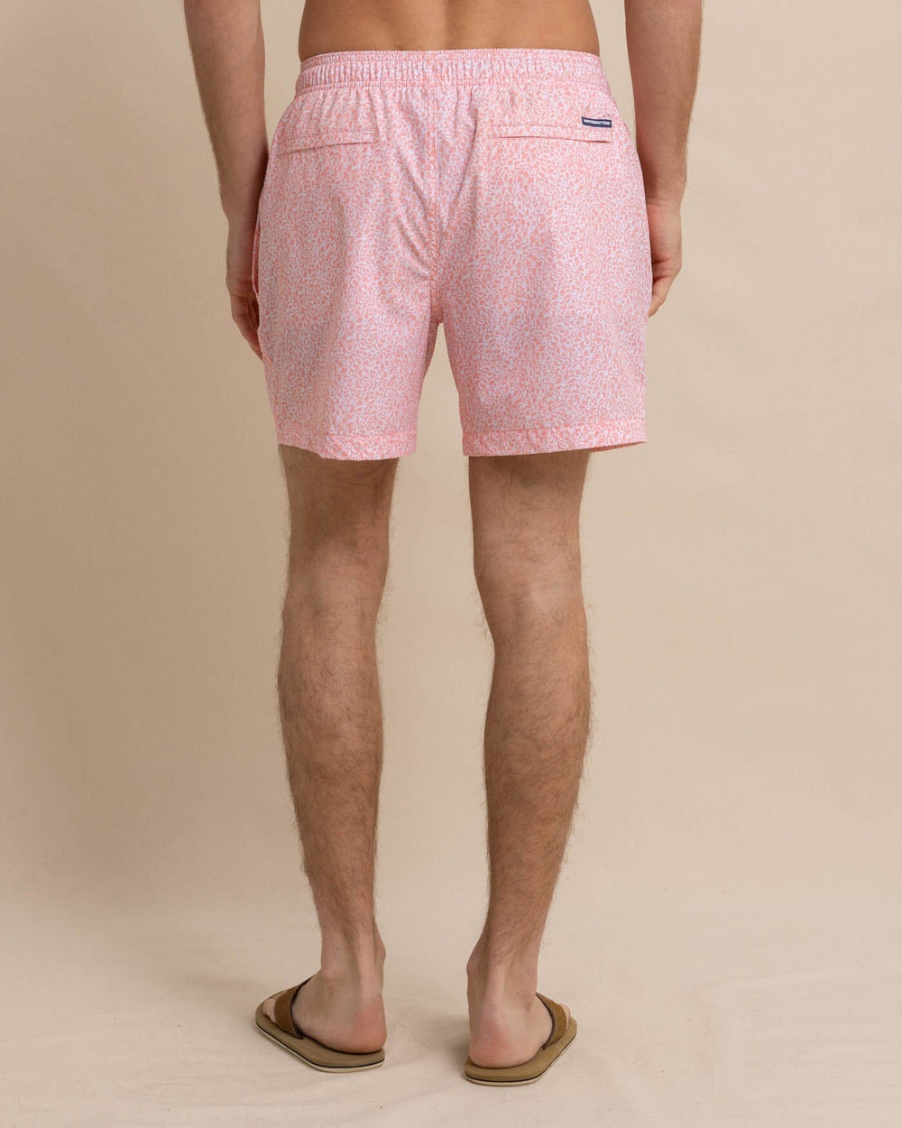 The back view of the Southern Tide That Floral Feeling Swim Trunk by Southern Tide - Apricot Blush Coral