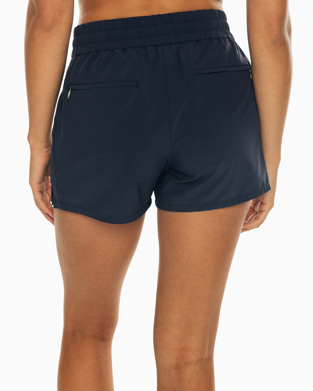 The back view of the Women's Navy Coastal Performance Solid Short by Southern Tide - Nautical Navy