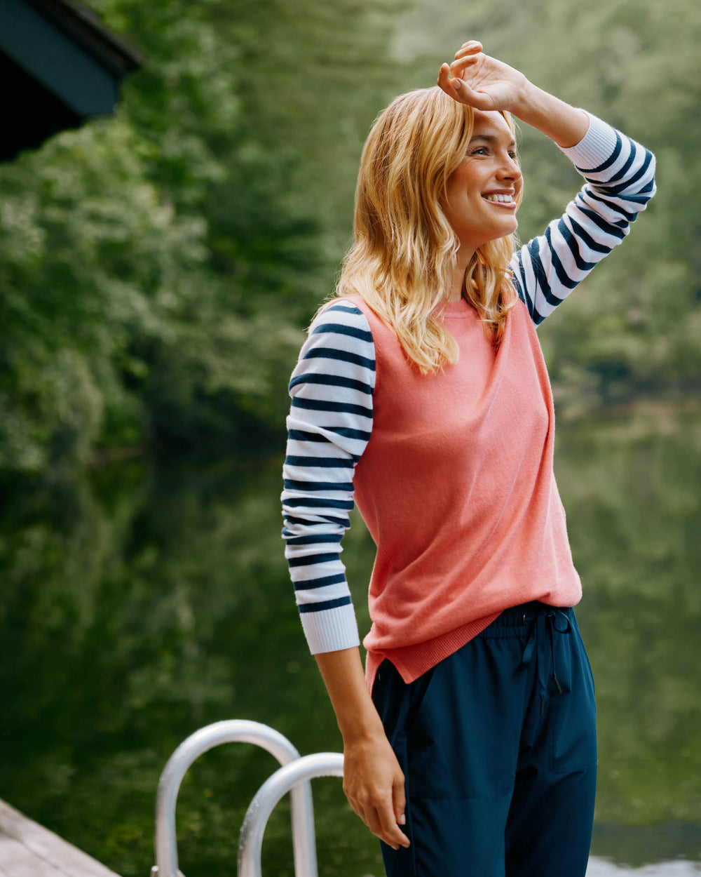 The front lifestyle view of the Color Block Stripe Fireside Sweater by Southern Tide - Mineral Red