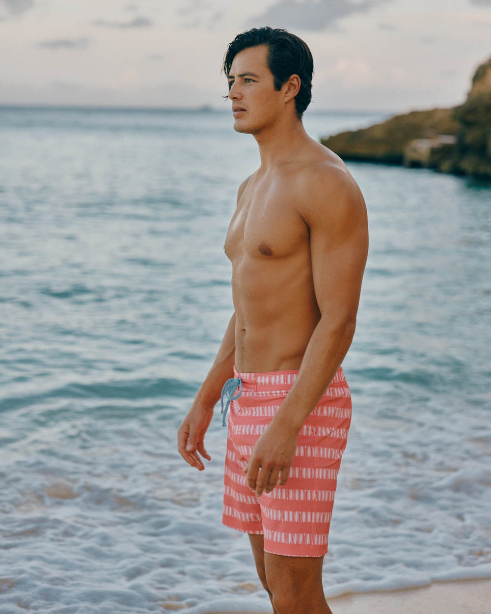 The lifestyle view of the Southern Tide Paddlin Out Printed Swim Short by Southern Tide - Sunkist Coral