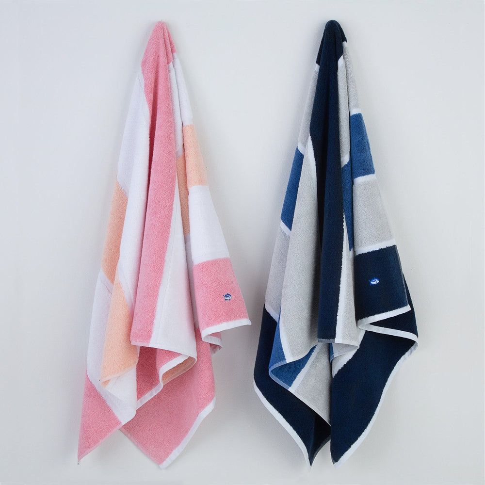 The front view of the Performance Striped Bath Towel in Coral by Southern Tide - Coral